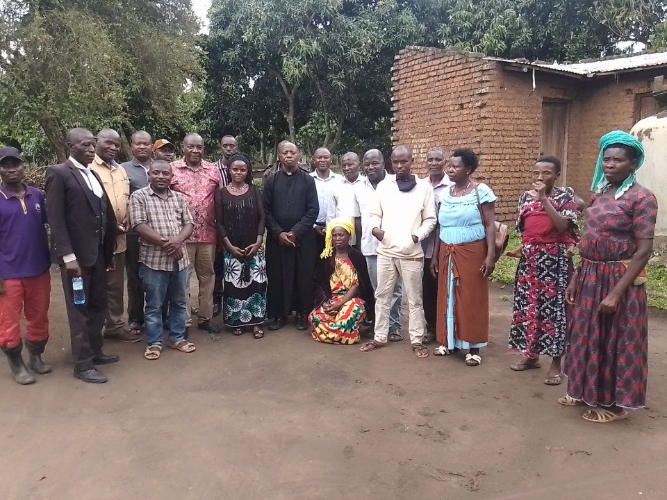 Community members posing for a photo with OWC Regional Coordinator Brigadier General Philip Mugarura at MOVFACOS, Kasese Uganda